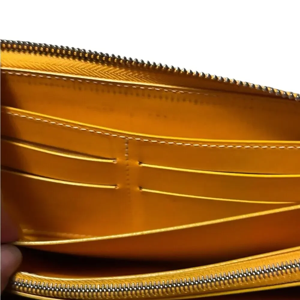 Goyard Matignon zip-around wallet in yellow orange Goyardine canvas.